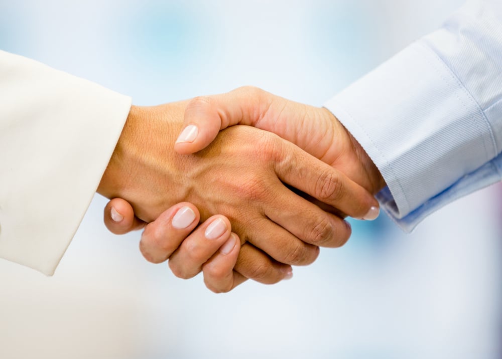 Business handshake closing a deal at the office